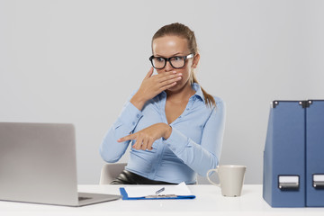 Shocked woman pointing at laptop