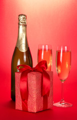 Champagne bottle, two wine glasses and gift box