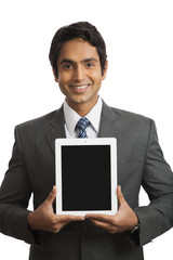 Portrait of a smiling businessman holding a digital tablet