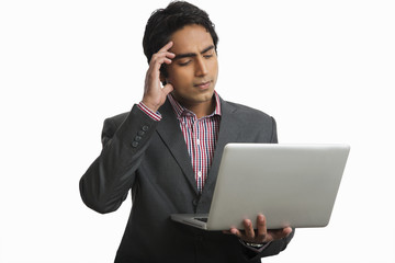 Businessman using a laptop and thinking