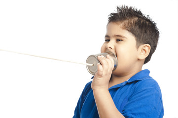 Close-up of a boy calling into a tin can phone