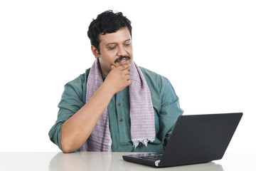 Man looking at a laptop and thinking