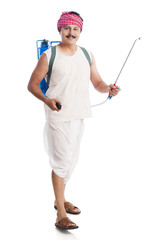 Portrait of a farmer carrying a crop sprayer and smiling