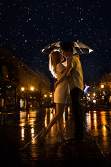 Love in the rain / Silhouette of kissing couple under umbrella