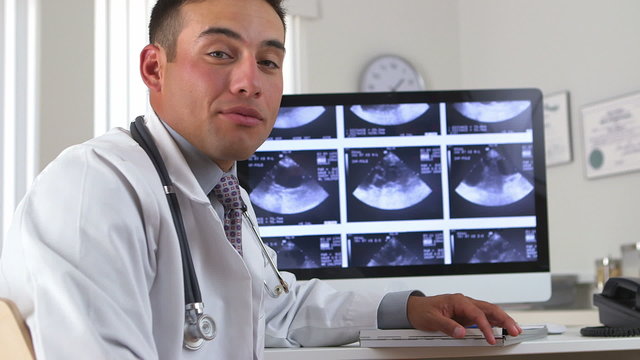 Hispanic doctor talking about sonogram on computer screen
