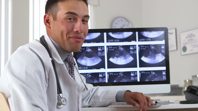 Latino doctor talking with green screen on computer in backgroun