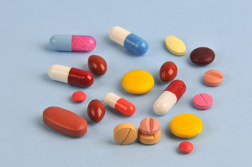 assortment of colorful pills and tablets isolated in blue