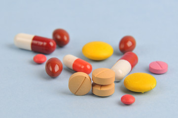 assortment of colorful pills and tablets isolated in blue