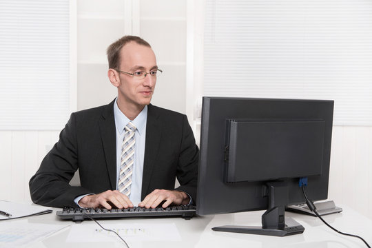 Typischer Beamter mit Anzug und Krawatte im Büro