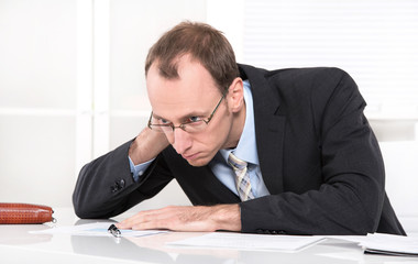 Managerkrankheit Burnout - Mann erschöpft und gestresst im Büro