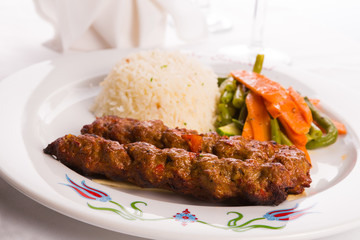 Adana Kebabs Served on a Lavash Bread Garnished with Vegetables