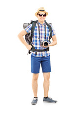 Male tourist with backpack and camera posing
