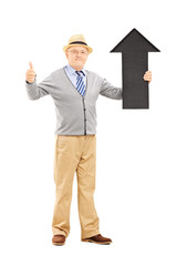 Smiling senior man holding arrow pointing up and giving thumb up