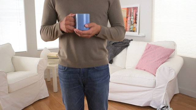 Smiling Latino man with cup of coffee