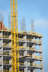 Crane and building construction site against blue sky