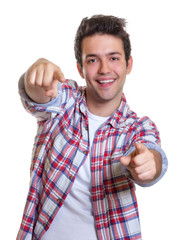 Mann mit karriertem Hemd zeigt mit beiden Fingern zur Kamera