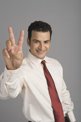 Portrait of a businessman showing victory sign
