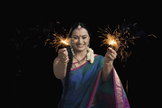 Woman celebrating Diwali festival with sparklers