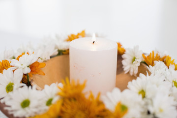 Fototapeta na wymiar Flowers and a lit candle