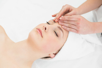 Obraz na płótnie Canvas Hands massaging a beautiful woman's forehead