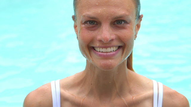 Healthy woman swimming to pool edge