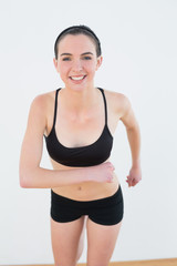 Fototapeta na wymiar Smiling toned young woman hips in fitness studio