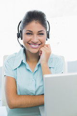 Businesswoman wearing headset in front of laptop