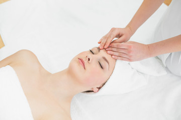 Fototapeta na wymiar Hands massaging a beautiful woman's forehead