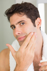 Obraz premium Man applying moisturizer on face