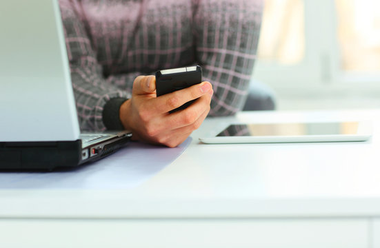 Closeup image of a male hand holding smartphone