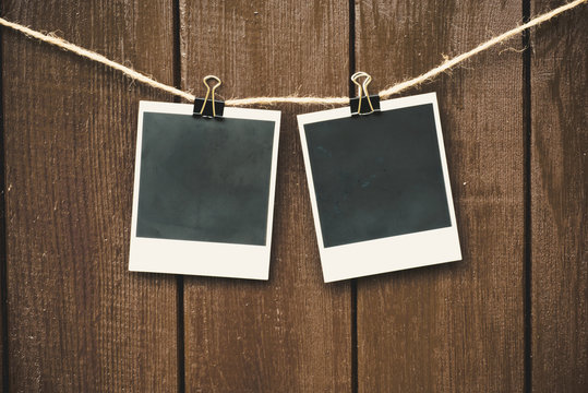 Blank photo frames on a wooden background. Black old pictures. 