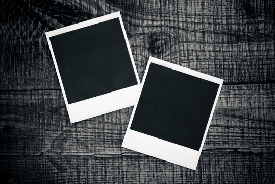 Blank photo frames on a wooden background
