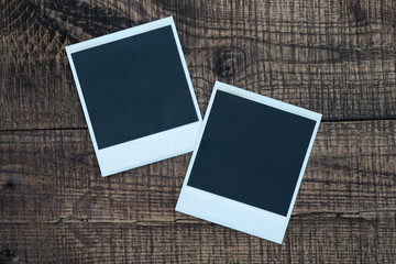 Blank photo frames on a wooden background