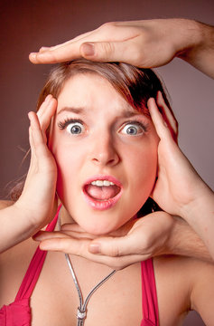 Closeup portrait of woman surrounded by hands shouting loud