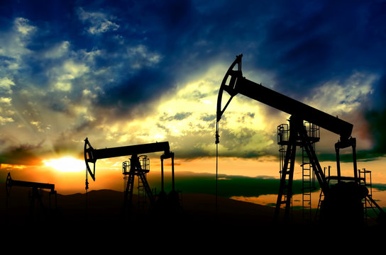 Oil pumps working on sunset background