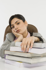 Businesswoman with stack of books on a desk