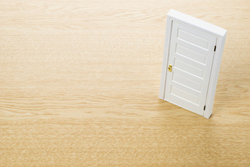 木目の背景にドアの模型