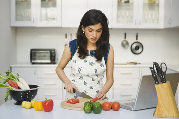 Woman chopping tomatoes in the kitchen
