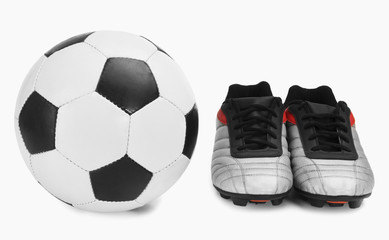 Close-up of a soccer ball with a pair of shoes