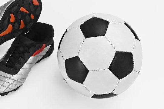 Close-up of a soccer ball with a pair of shoes