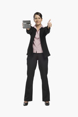Businesswoman holding a calculator and showing thumbs up sign