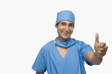 Portrait of a surgeon showing thumbs up and smiling