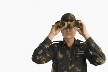 Army soldier looking through binoculars
