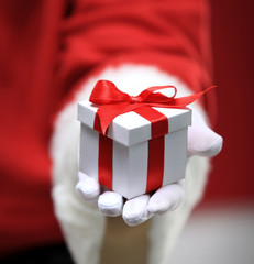 Photo of Santa Claus gloved hands holding white giftbox