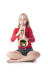young girl in red playing trumpet