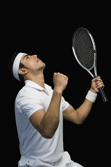 Tennis player celebrating with his arms raised