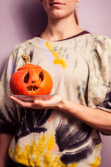 Young woman holding a scary jack-o-lantern