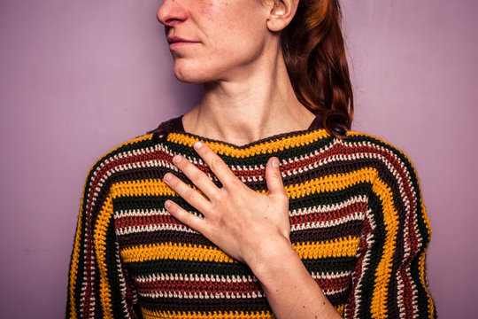 Young woman touching her chest