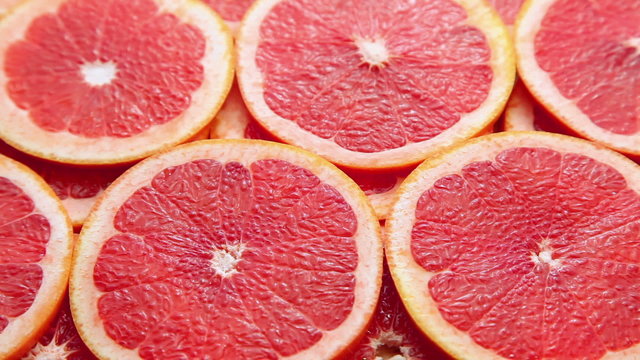 Red grapefruit slices, motion background with fruit