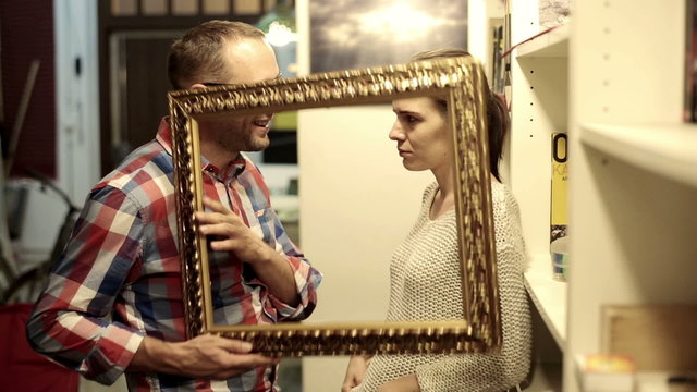 Couple fighting and loving with the  frame standing in room